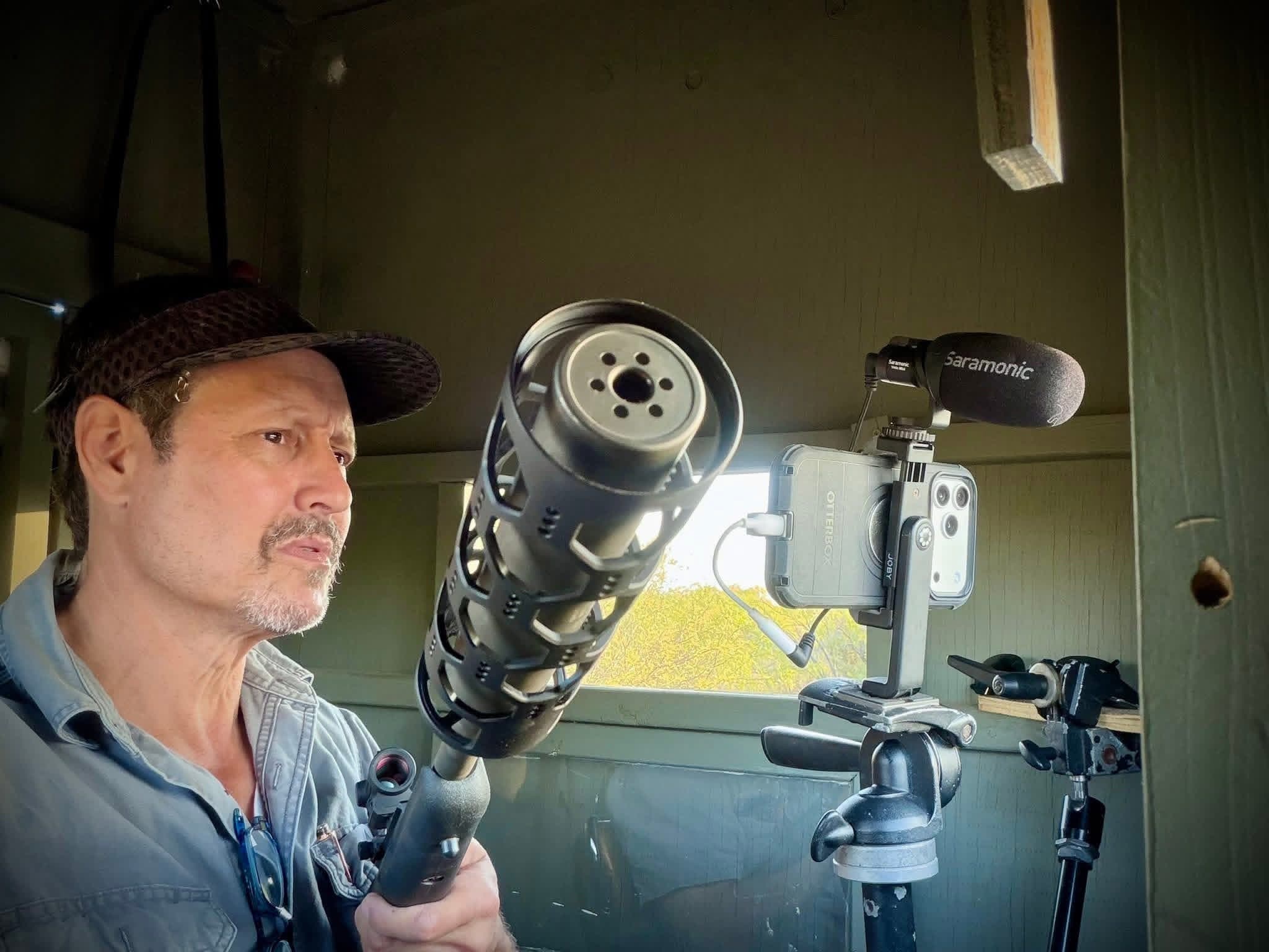 A videographer sets up a professional camera and shotgun microphone inside a hunting blind at Brochin Expeditions.